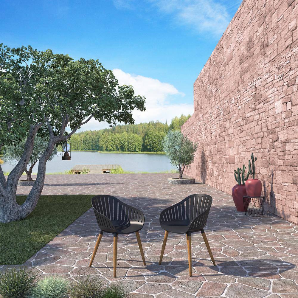 Two black contemporary outdoor armchairs with teak wood legs.