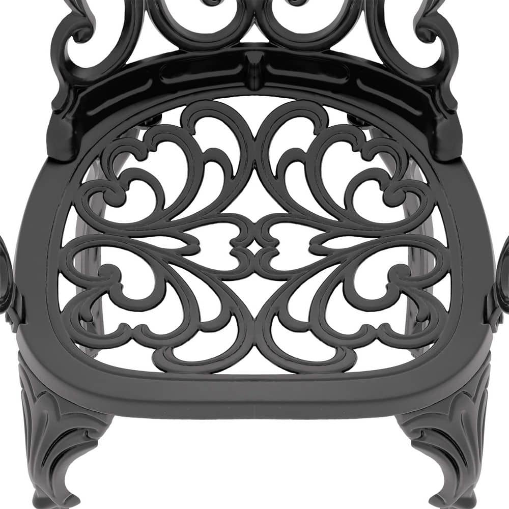 Close-up of the ornate filigree seat of a black aluminum chair.