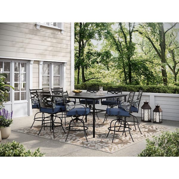 Hanover Montclair 9-Piece Steel Outdoor Dining Set with Navy Blue Cushions, 8 Swivel Chairs and 60 in. Counter Height Table