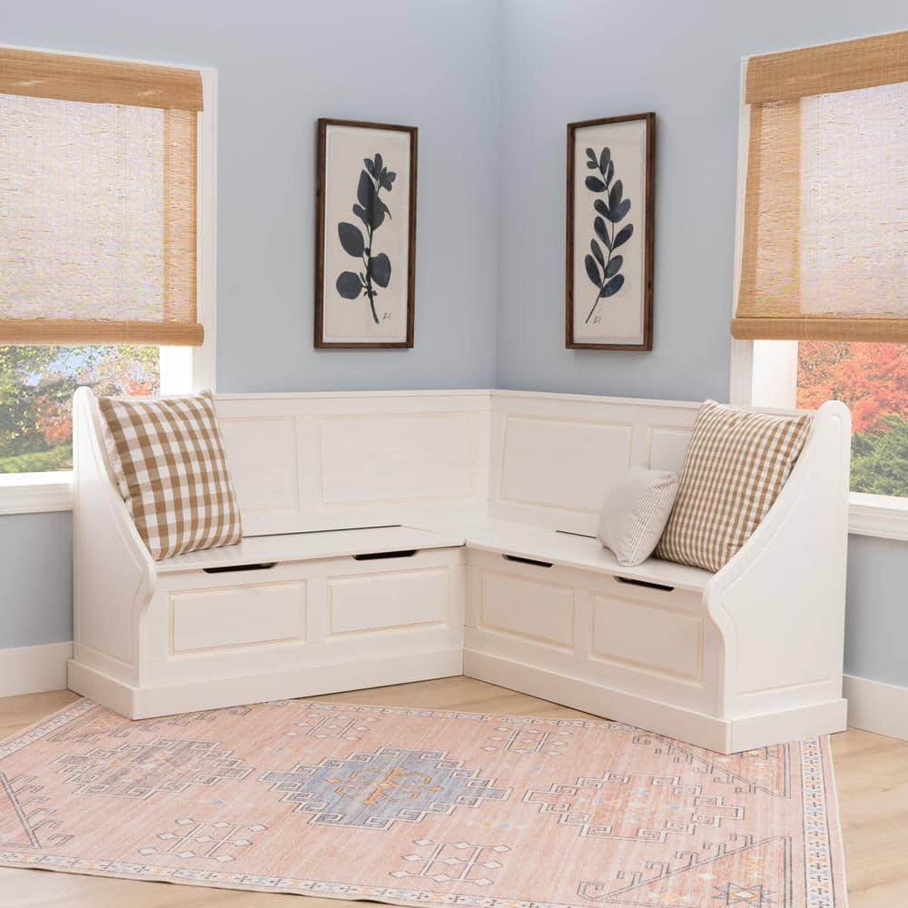 White corner nook dining bench with checkered pillows.