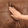 Close-up of the texture of the brown leather upholstery.