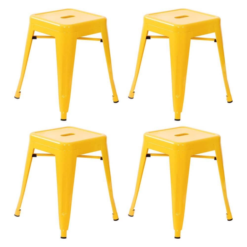 Set of four yellow backless metal bar stools.