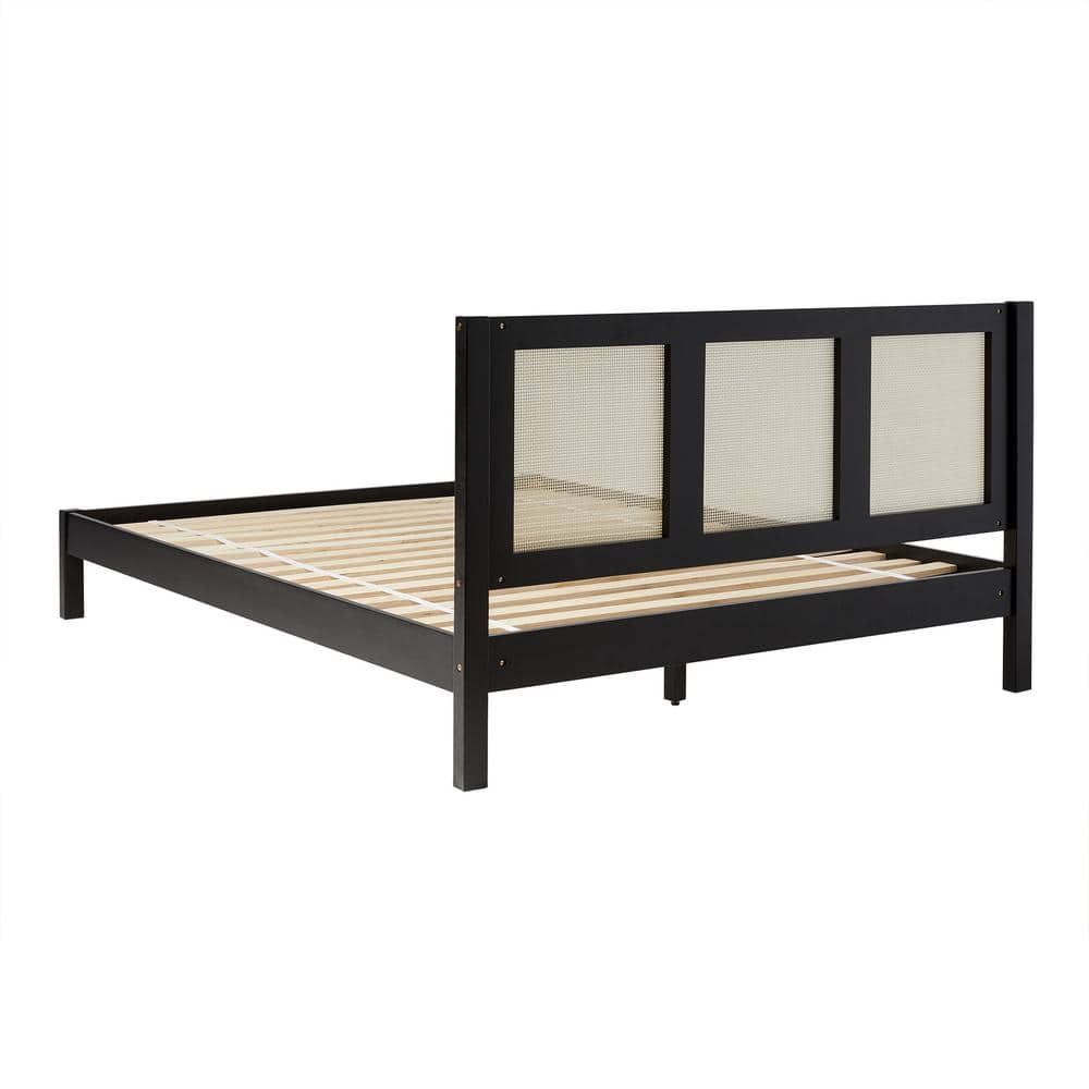 Angled view of a black wood frame queen platform bed with rattan headboard.