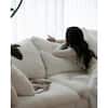 Woman relaxing on a white sectional sofa reading a book.