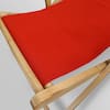 Close-up of the red canvas fabric on a wooden sling chair.