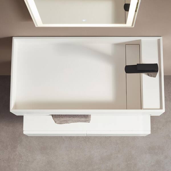 White modular shelves are mounted beside a drop-in bathtub fitted with  white horizontal surround tiles…