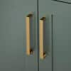 Close-up of gold rectangular pull handles on the sage green vanity doors.