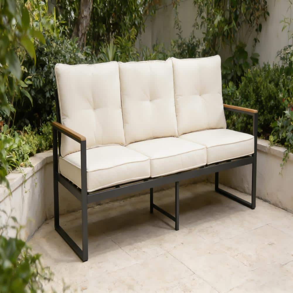 Three-seat metal outdoor patio sofa with beige cushions in a garden.