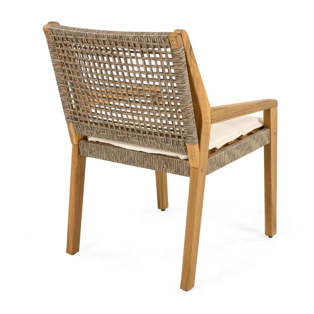 Single outdoor dining chair with teak frame, wicker back, and cream cushion.