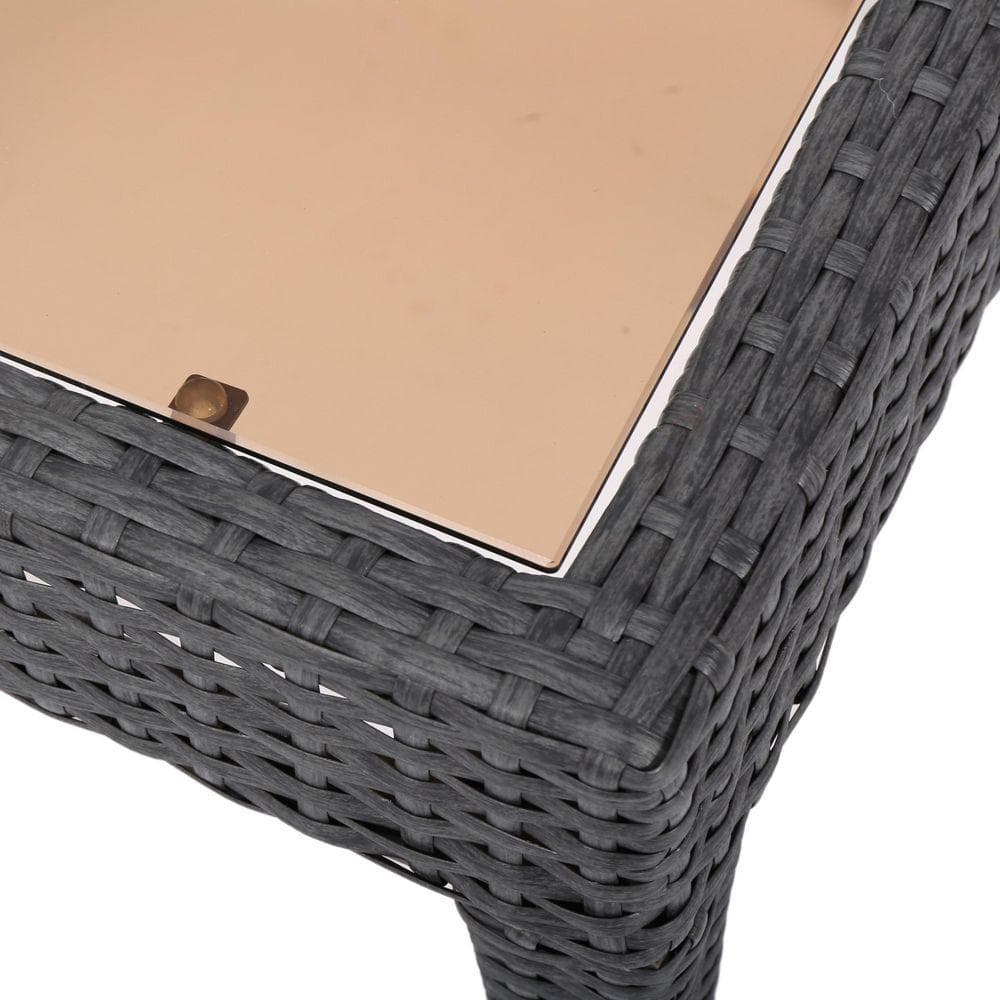 Close-up of the glass top and wicker edge of the side table.