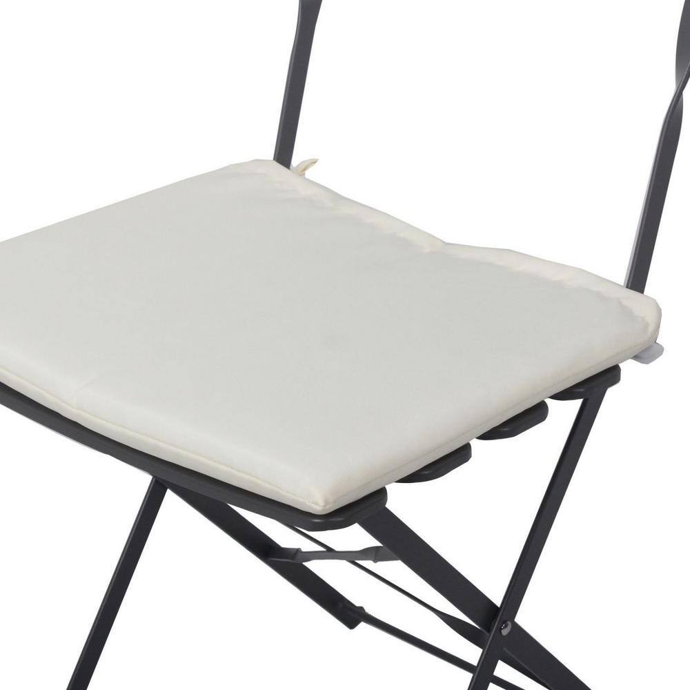 Top-down view of a beige cushion on a gray metal foldable chair.