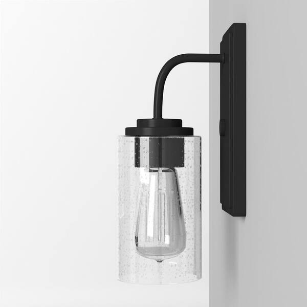 Designers Fountain - Logan 4.5 in. 1-Light Matte Black Transitional Wall Sconce with Clear Seedy Glass Shade