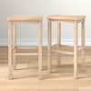 Pair of blonde wood bar stools shown in a hero shot.