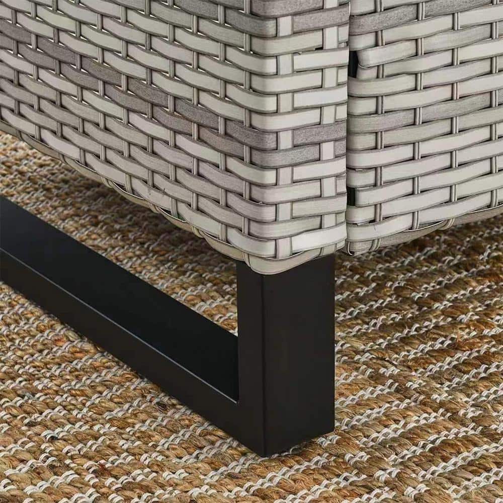 Close-up of the light beige wicker texture and black metal base.