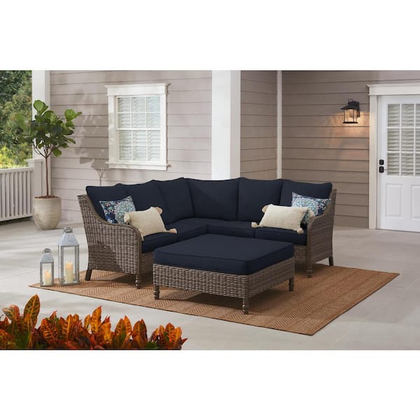 Hampton Bay Windsor 4-Piece Brown Wicker Outdoor Patio Sectional Sofa with Ottoman and CushionGuard Midnight Navy Blue Cushions