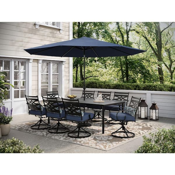 Hanover Montclair 9-Piece Steel Outdoor Dining Set with Navy Blue Cushions, 8 Swivel Rockers, 42 in. x 84 in. Table and Umbrella