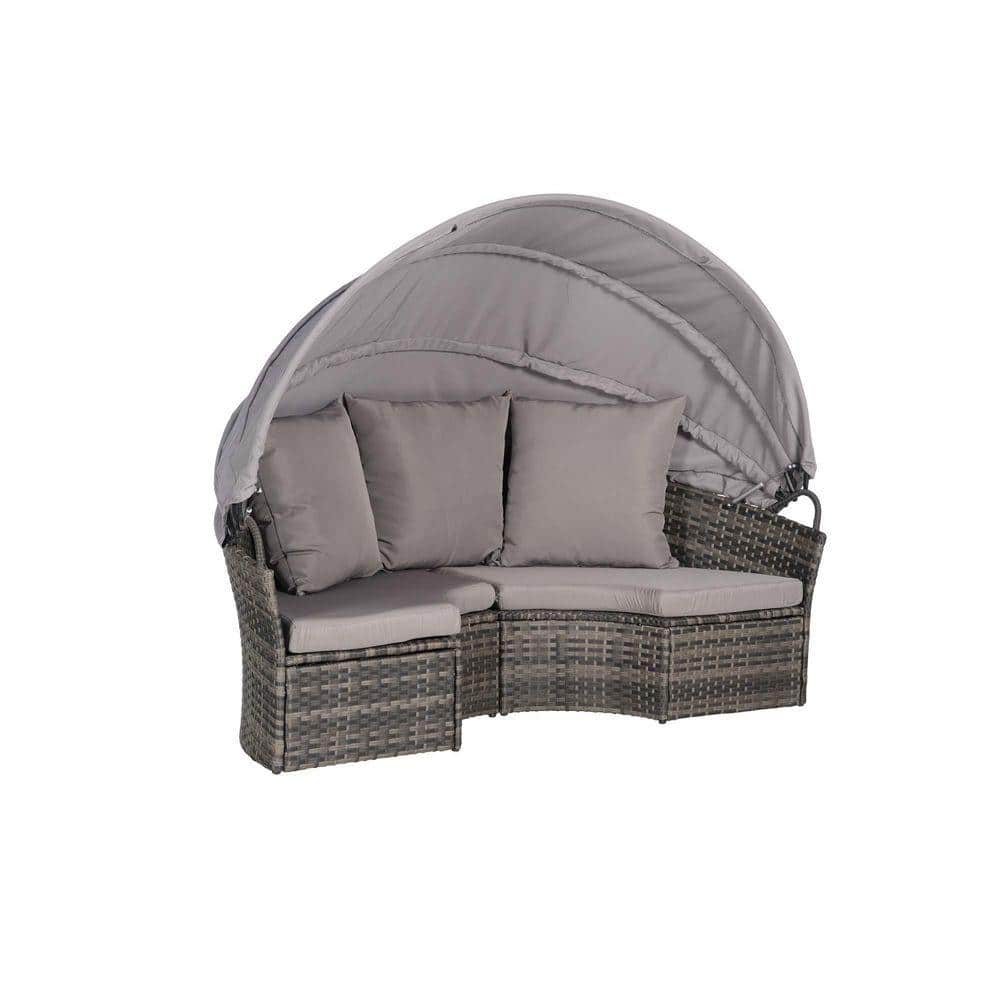 Curved gray wicker outdoor patio sofa with dark gray cushions and a retractable canopy.