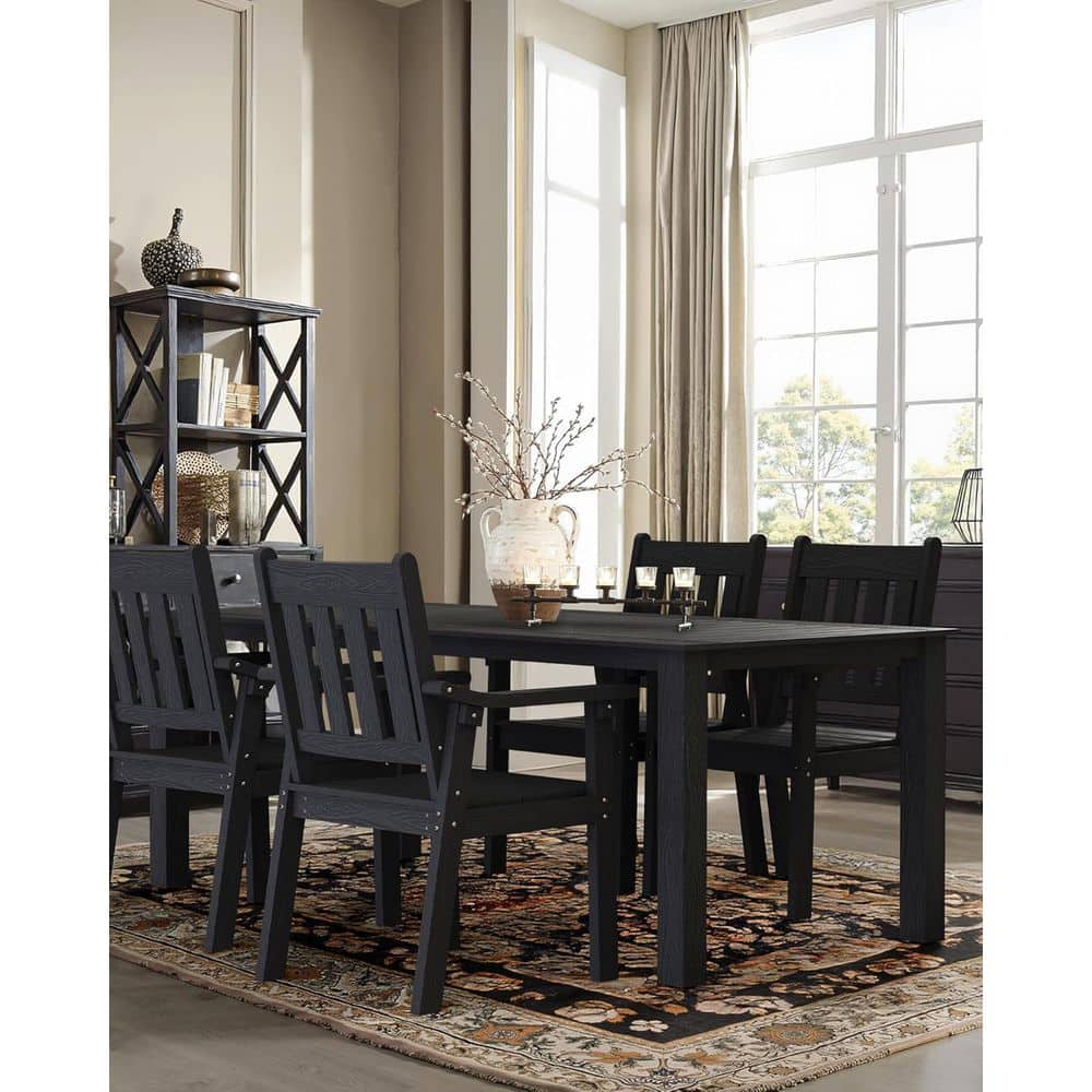 Black plastic patio dining set in an indoor room setting.