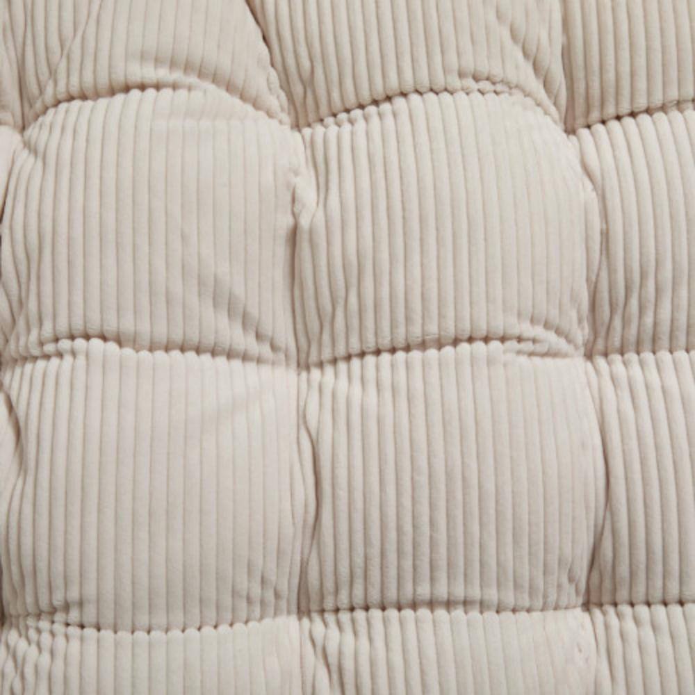 Close-up detail of the quilted texture of the white cushion.
