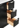 Close-up of open drawers on a black fluted bathroom vanity showing dovetail joints.