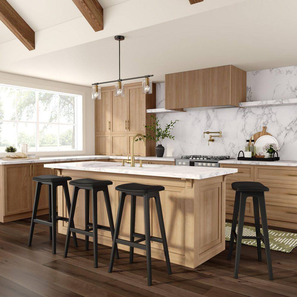 Four black bar stools lined up at a kitchen island.