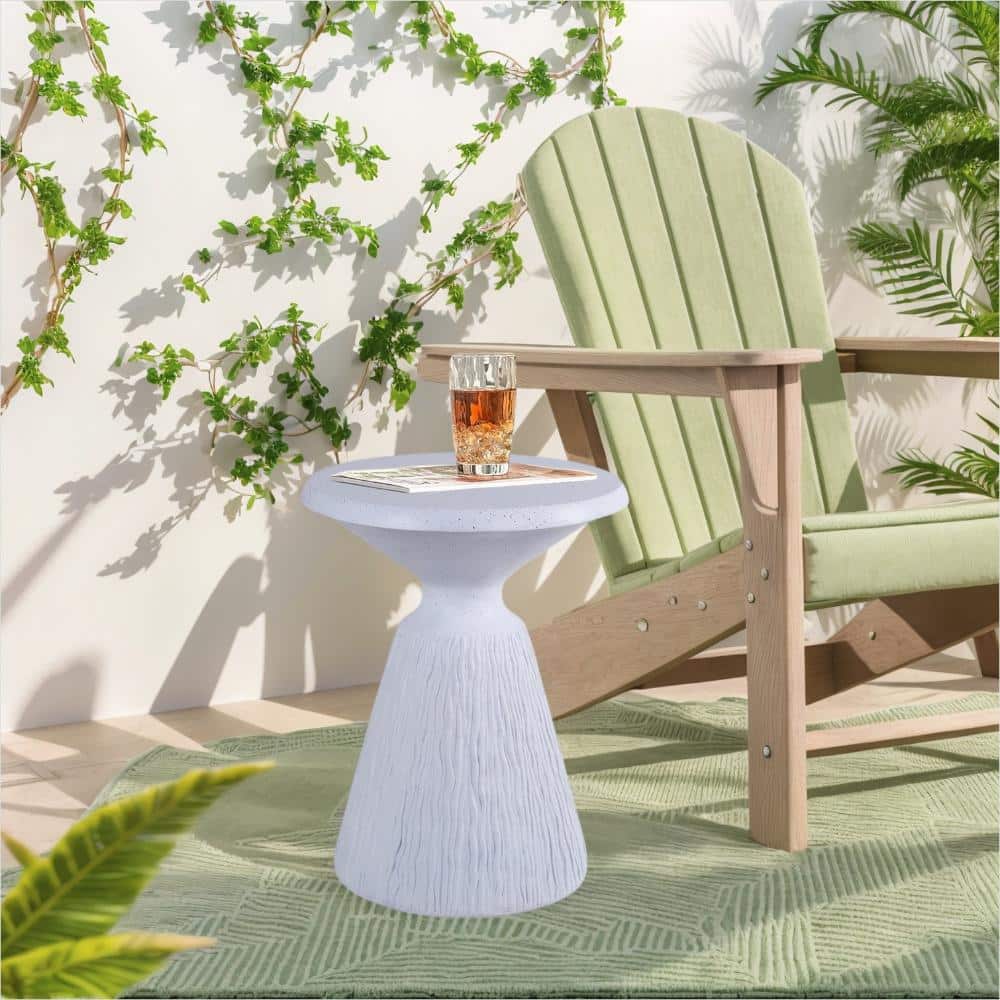 Round white end table placed on an outdoor patio setting with a green chair.