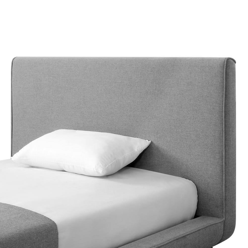 Close-up of the grey linen upholstered headboard and frame of the platform bed.