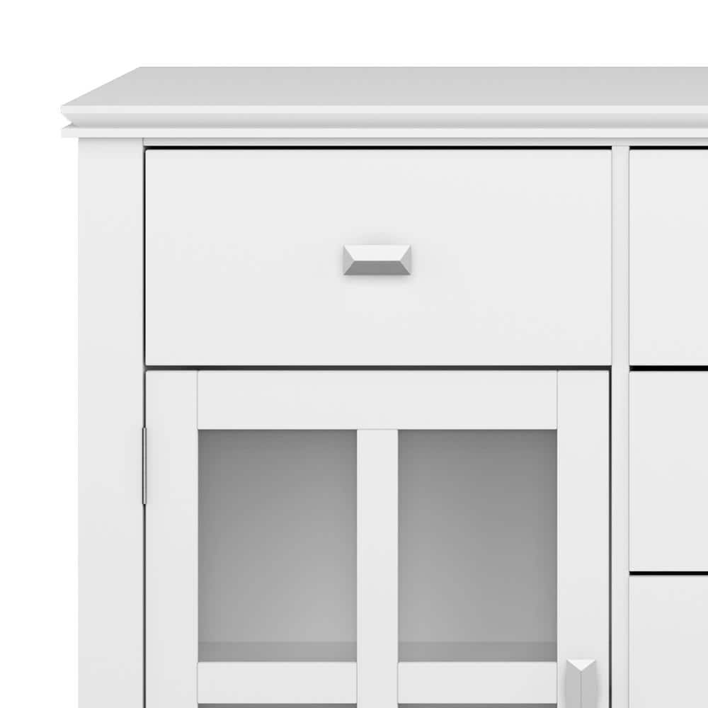 Close-up of a white drawer with a silver handle on a sideboard.