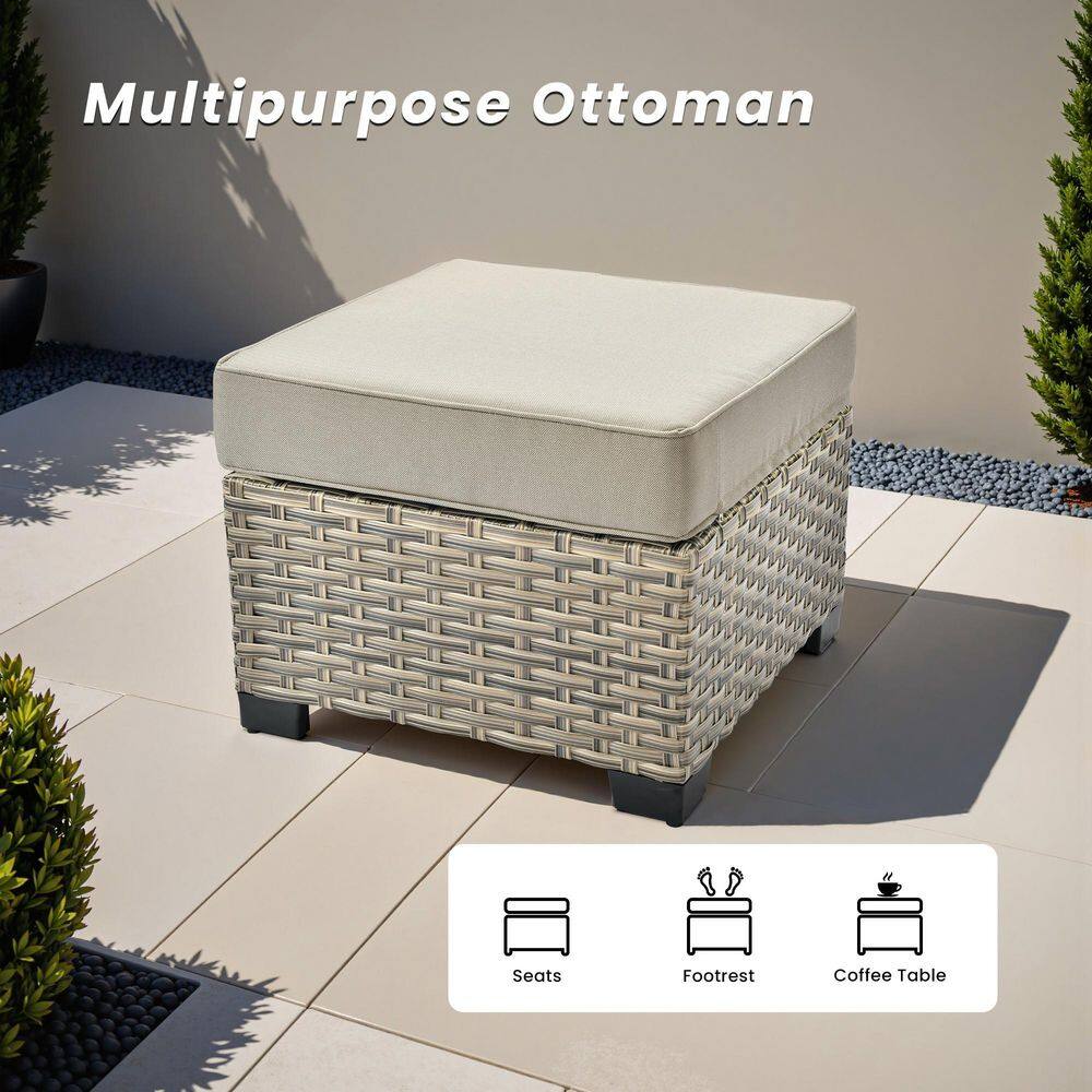 A square gray wicker ottoman with a beige cushion.