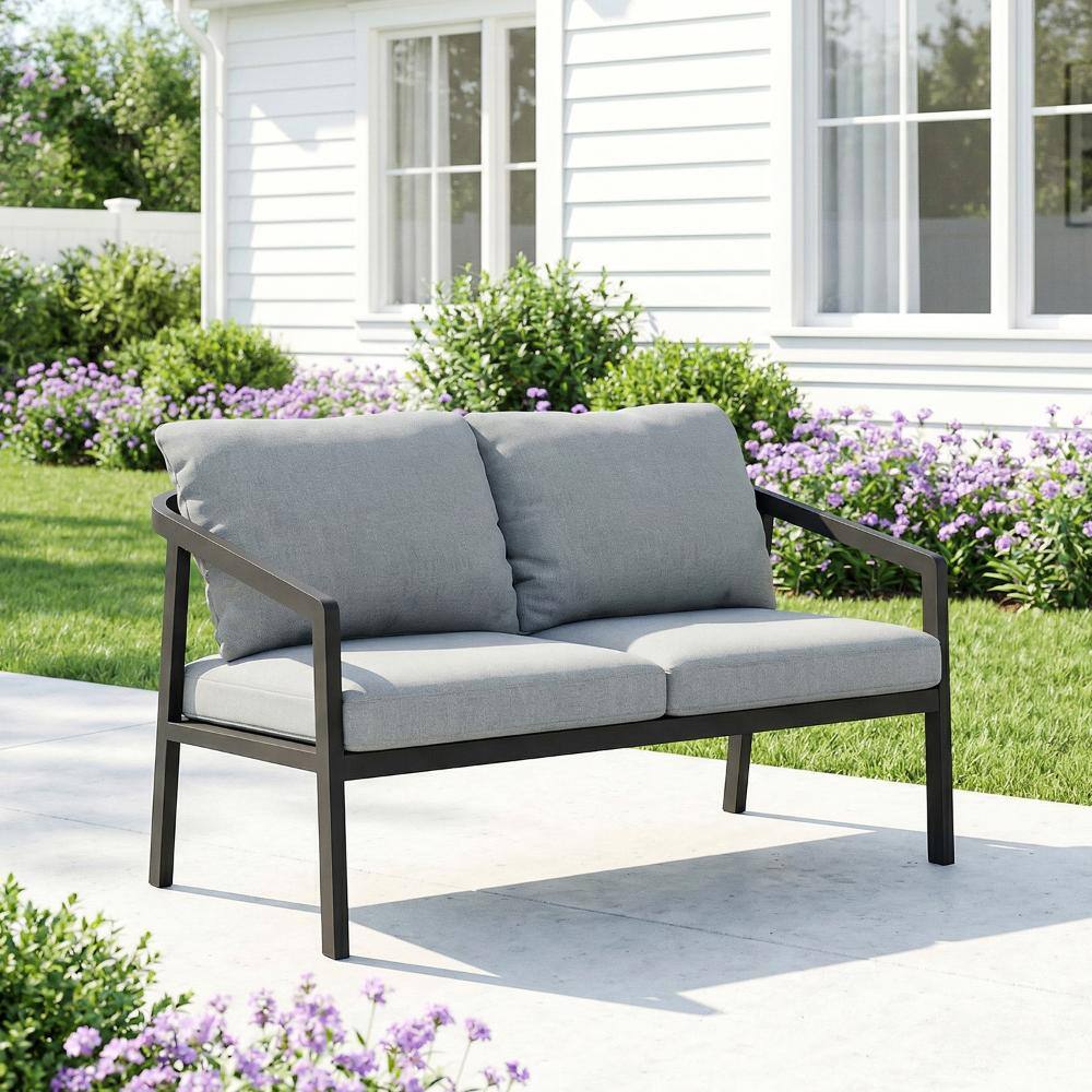Black aluminum outdoor loveseat with grey cushions in a garden setting.