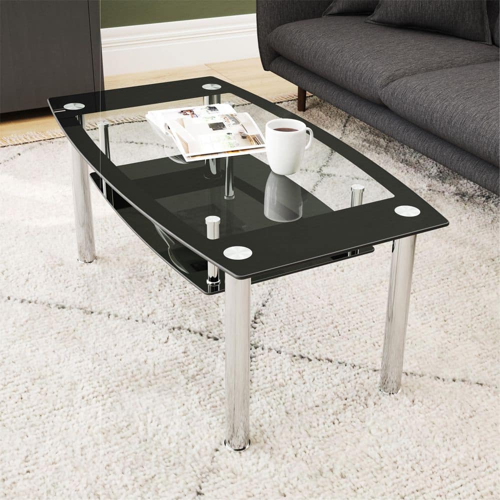 Rectangle glass coffee table with black and clear glass tiers and chrome legs in a living room setting.