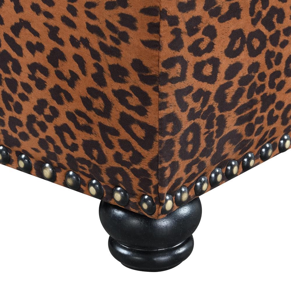 Close-up of the leopard print fabric and nailhead trim on the ottoman.