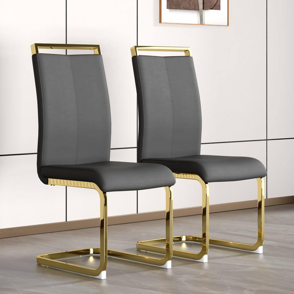 Two modern dark gray PU leather dining chairs with gold metal frames.