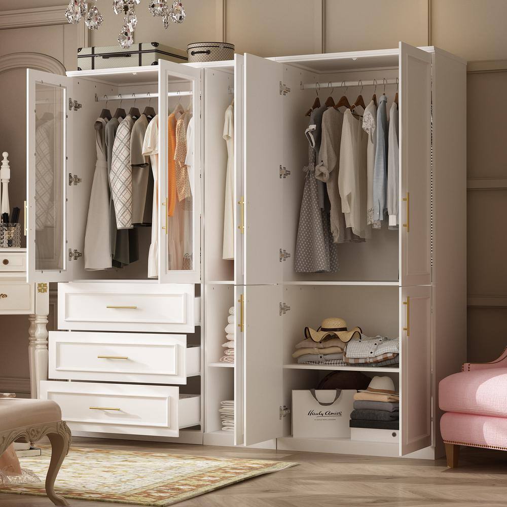 Open white armoire with drawers partially extended and clothes hanging inside.