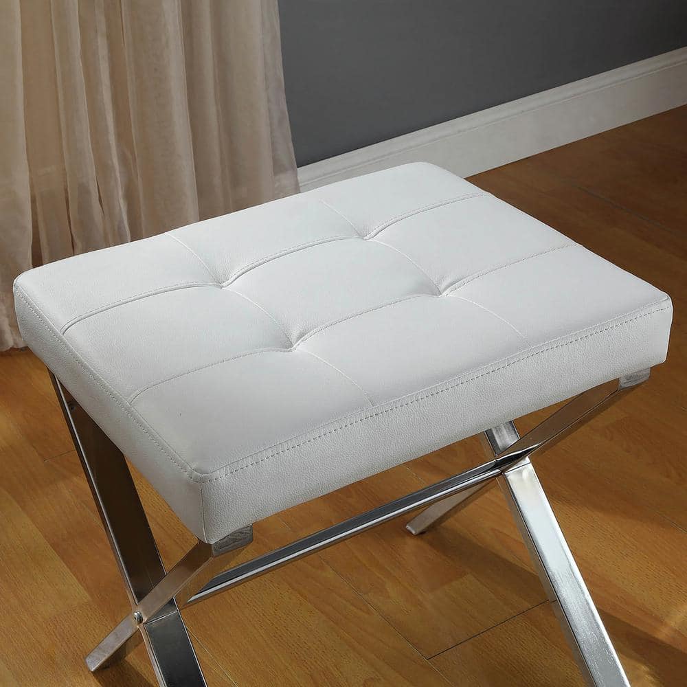 High-angle view of the white tufted seat and chrome legs of the vanity bench.