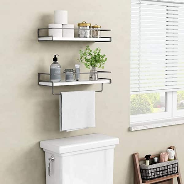 White stacked floating shelves are mounted in a nook above a drop in bathtub  fitted with a white subway tile…