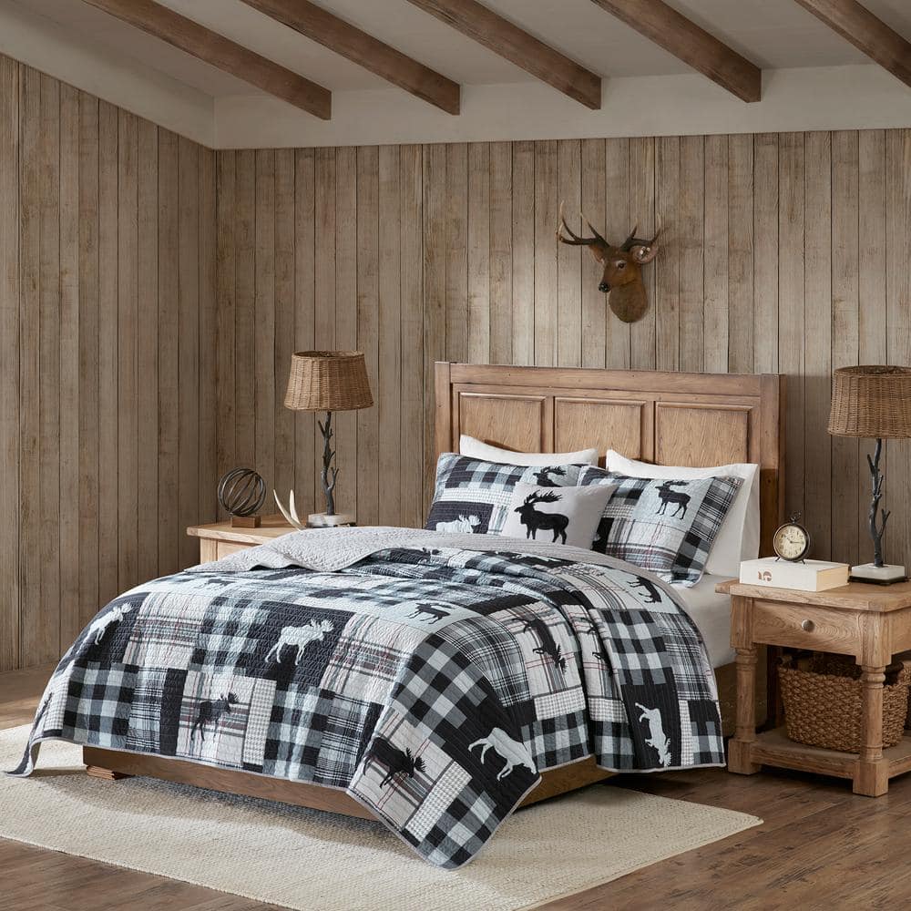 Woolrich Sweetwater 4-Piece Black/Grey Full/Queen OversizedQuilt Set The Woolrich Sweetwater 4 Piece Quilt Set features plaid prints and a moose motif in black and grey hues. This oversized quilt can be used year round. A solid reverse complements the top of the bed, while the coordinating shams and decorative pillow complete the ensemble. This quilt set transforms your bedroom into a relaxing cabin retreat and is machine washable for easy care. Color: Black/Grey.