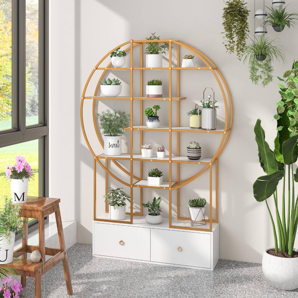 Bunpeony gold circular bookcase used as a plant stand in a bright room.