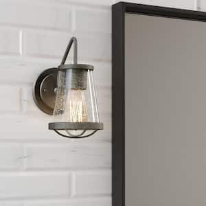Georgina 5.75 in. 1-Light Weathered Iron Industrial Wall Sconce with Clear Seeded Glass Shade and Cage Accent