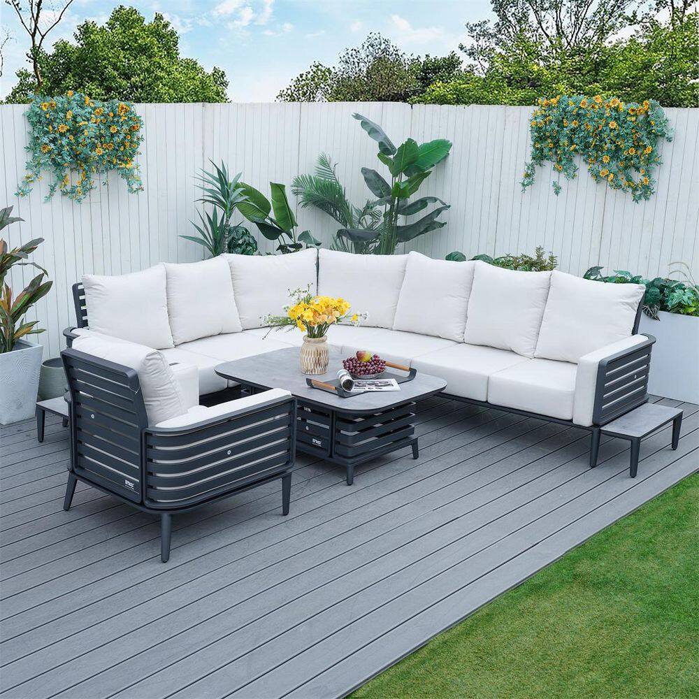 Dark grey wicker patio conversation set with white cushions on a wooden deck.