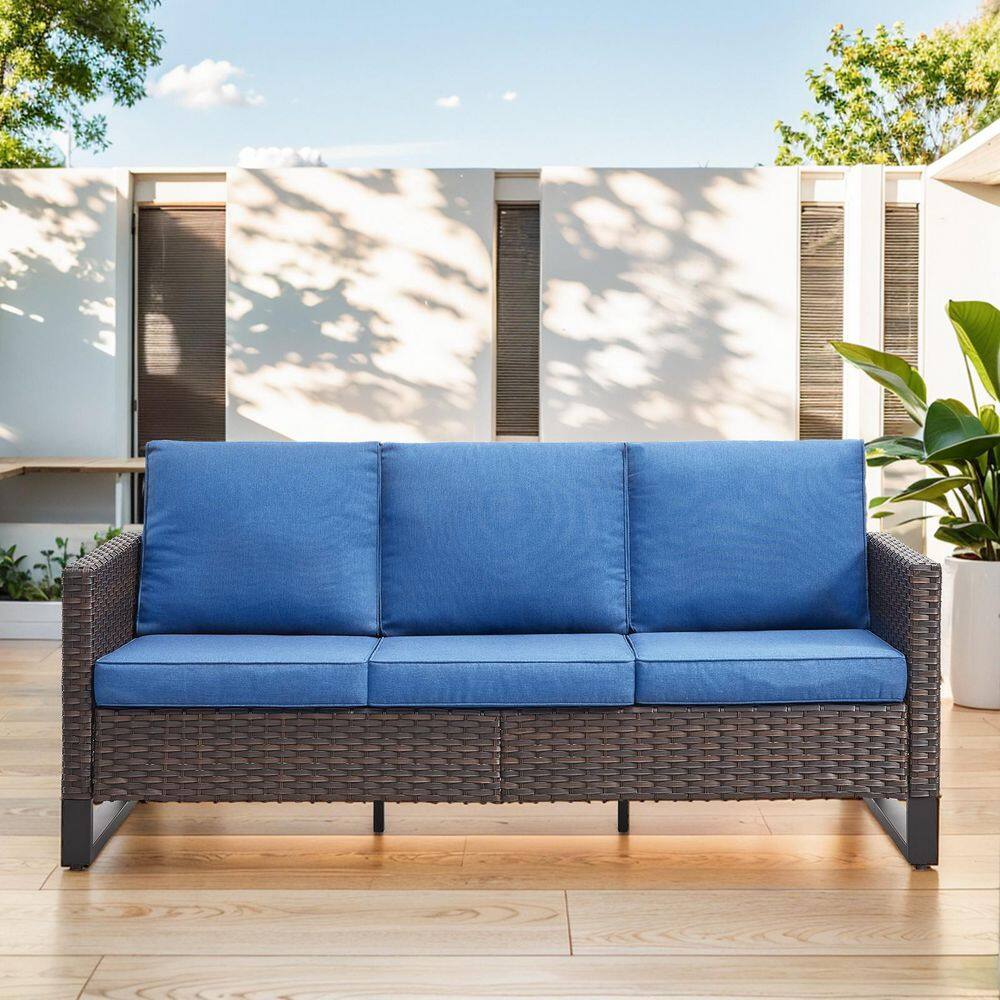 Three-seat brown wicker outdoor patio couch with blue cushions.