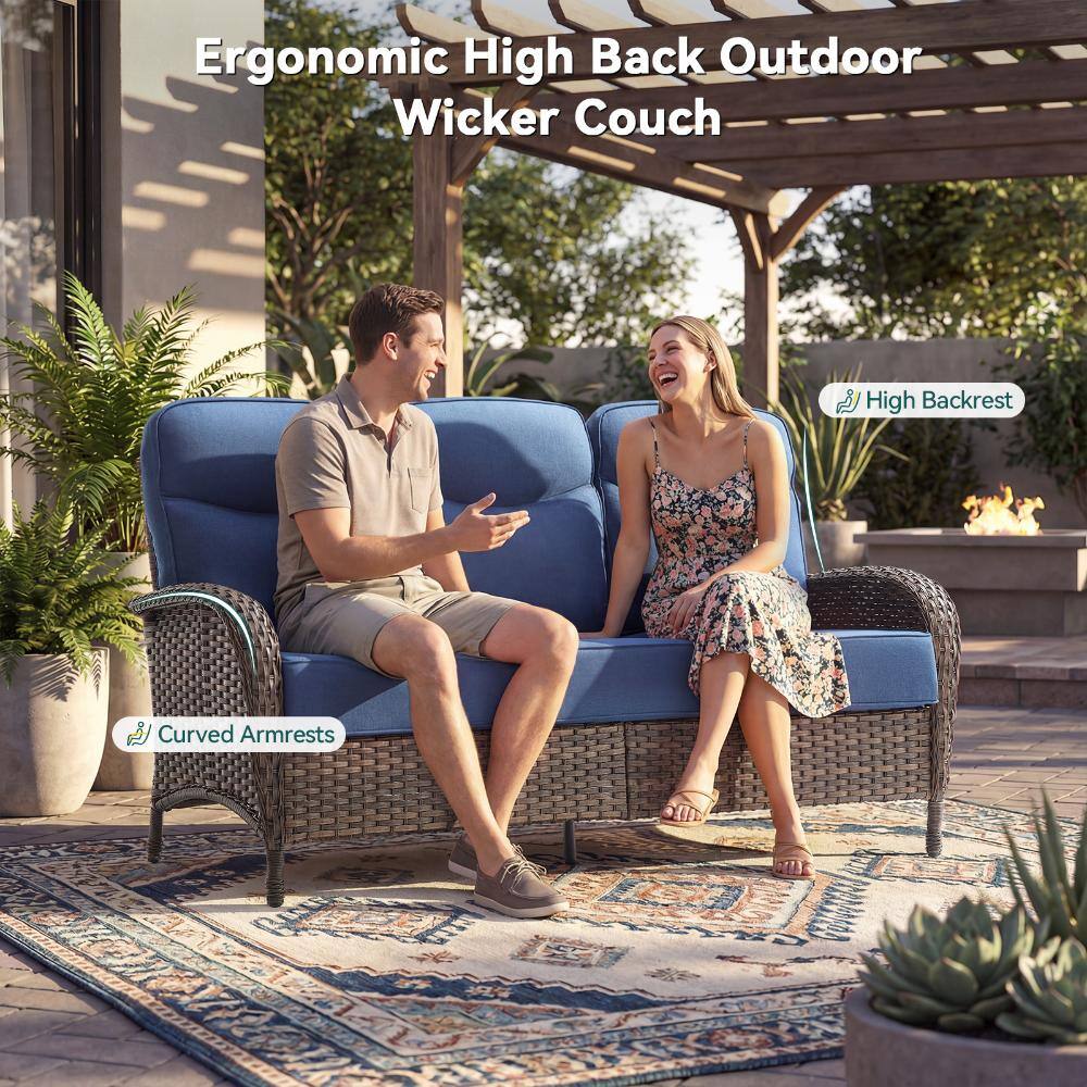 Couple relaxing on an outdoor wicker couch.