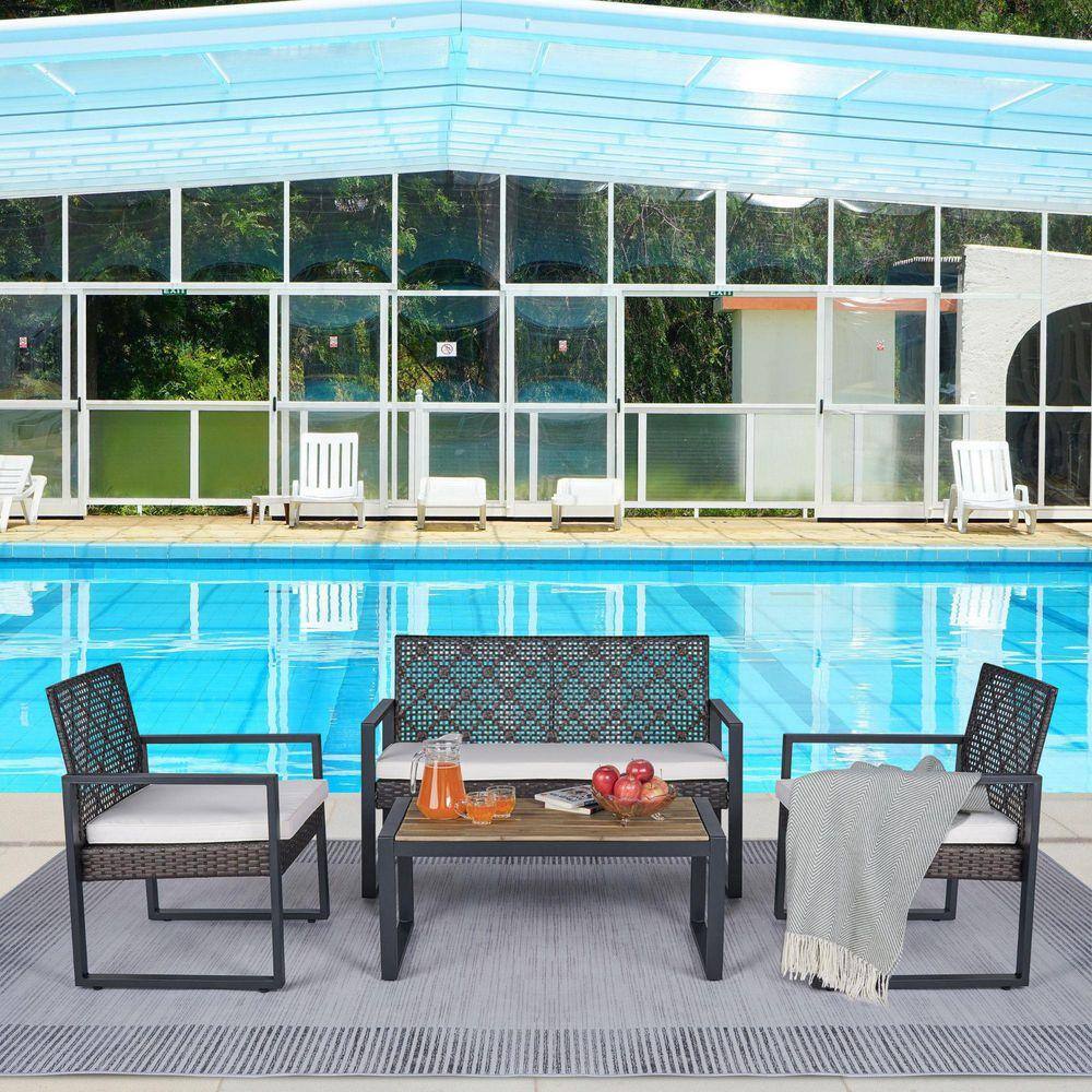 Patio furniture set arranged outside near a swimming pool.