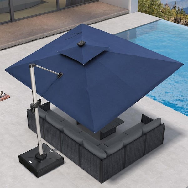 9 ft. x 12 ft. Sunbrella Aluminum Solar Powered LED Cantilever Offset Patio Umbrella with Base in Navy Blue