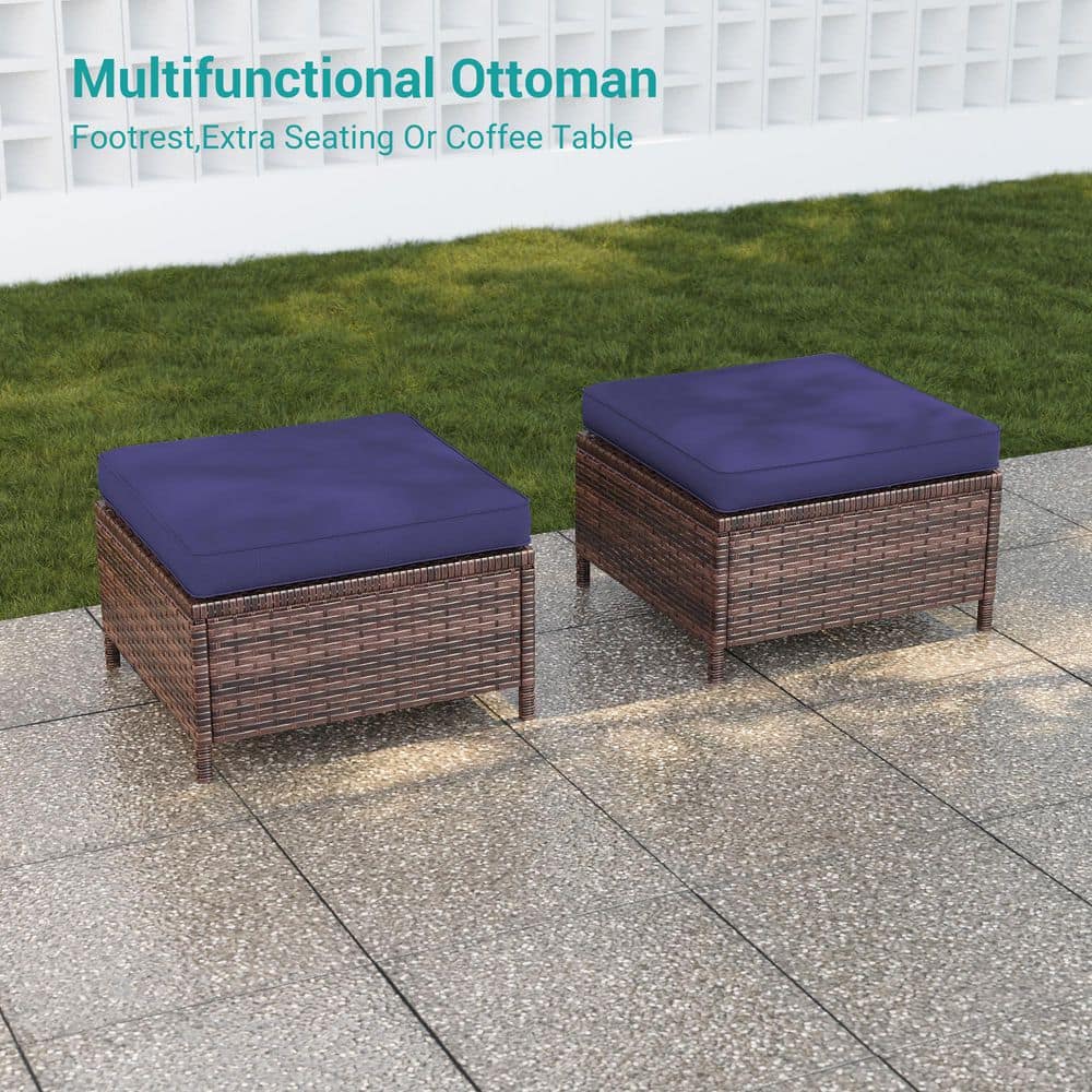 Two rectangular brown wicker ottomans with navy blue cushions.