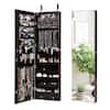 Brown wood wall-mounted jewelry armoire with mirrored doors shown with decorative plants.
