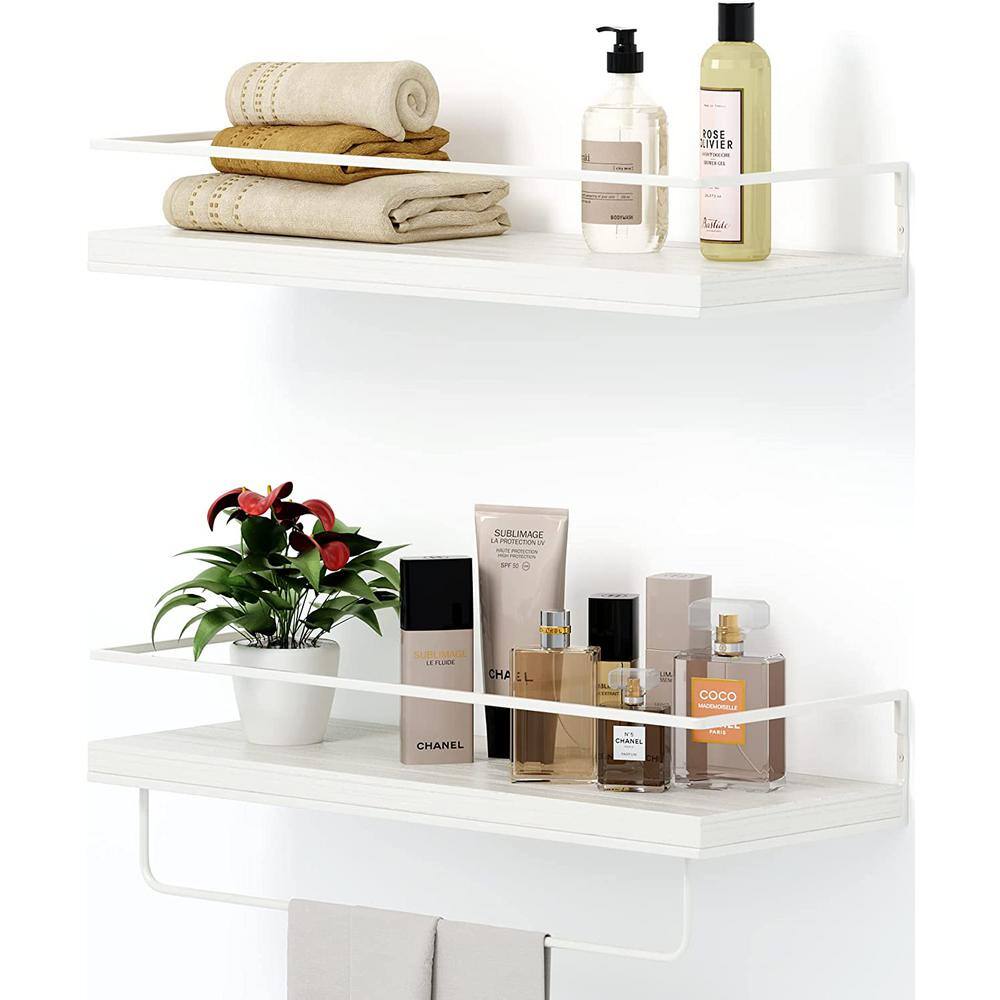 White modular shelves are mounted beside a drop-in bathtub fitted with  white horizontal surround tiles…