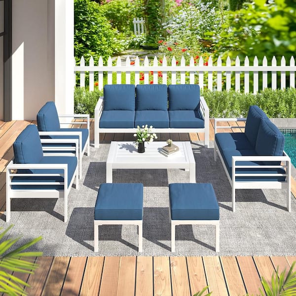 Outdoor conversation set with blue cushions on a wooden deck.