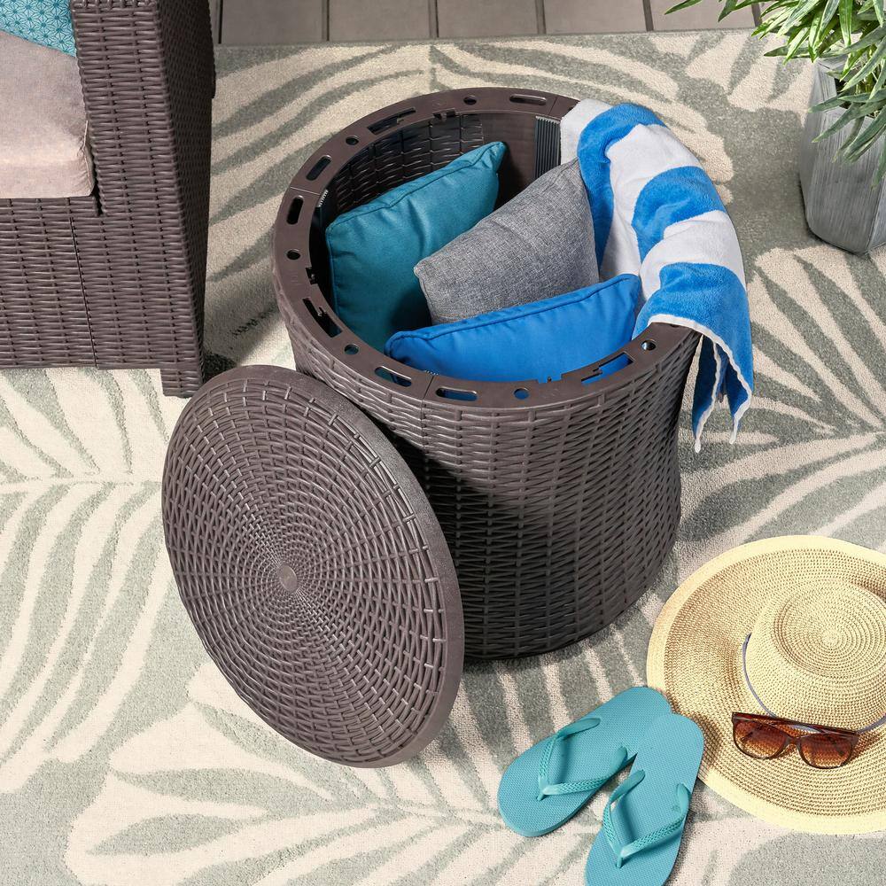 Dark brown woven plastic outdoor side table used as storage.