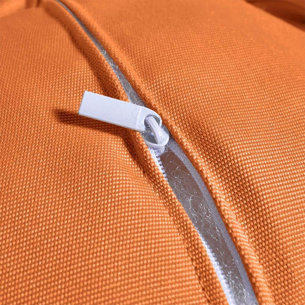 Close-up of the zipper on the orange cushion fabric.